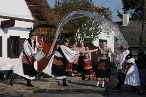 Hungarian youngsters on the countryside performing an Easter tradition, boys pouring water on girls from a bucket